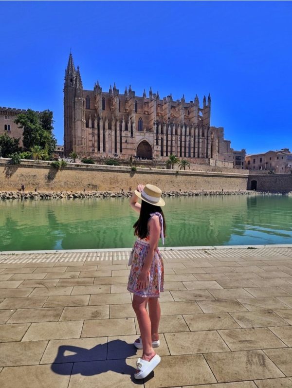 Gotycka fasada Katedry La Seu w Palma de Mallorca, odbijająca się w tafli słonego jeziora w parku Parc de la Mar o poranku.